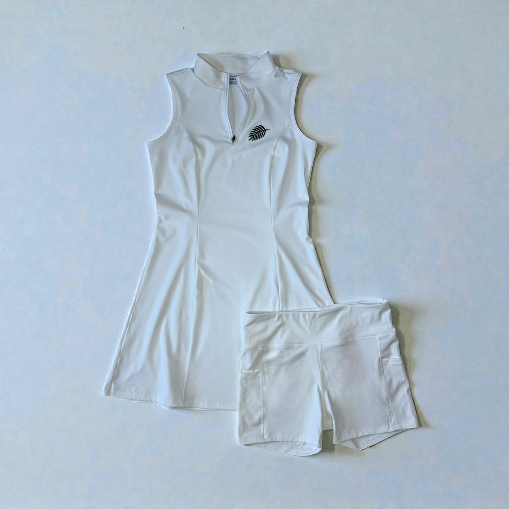 White sleeveless athletic top and shorts set on a light blue background