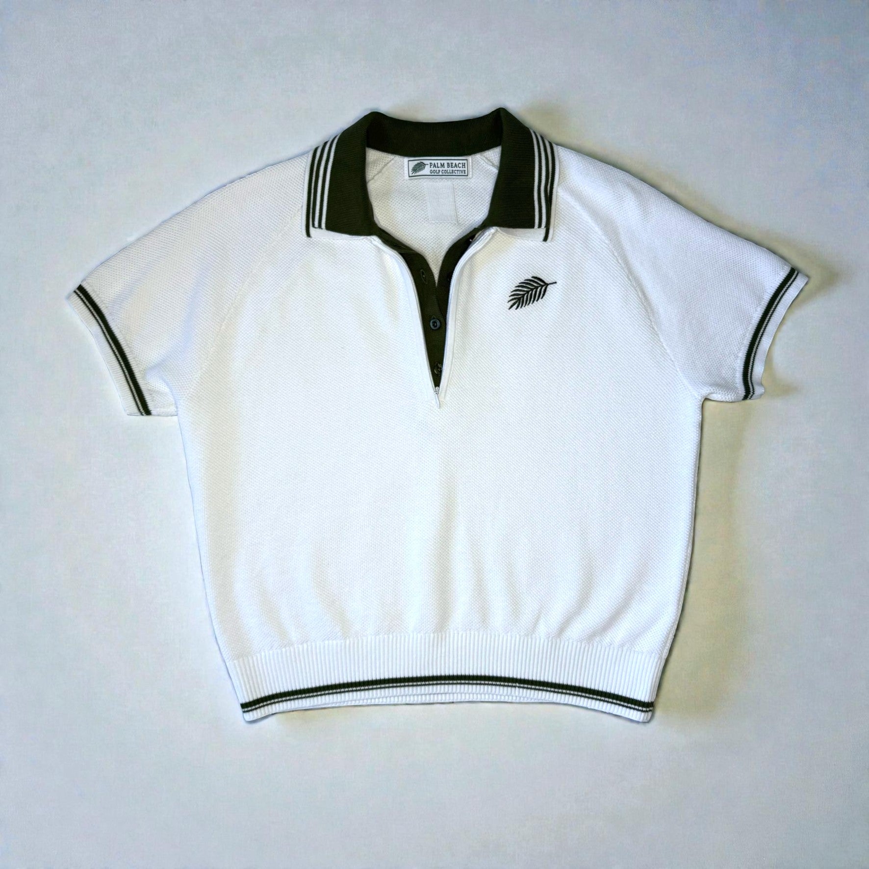 White polo shirt with green accents on a light gray background