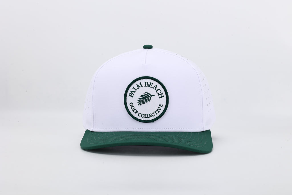 White cap with green brim and 'Palm Beach Golf Collective' logo on a light gray background