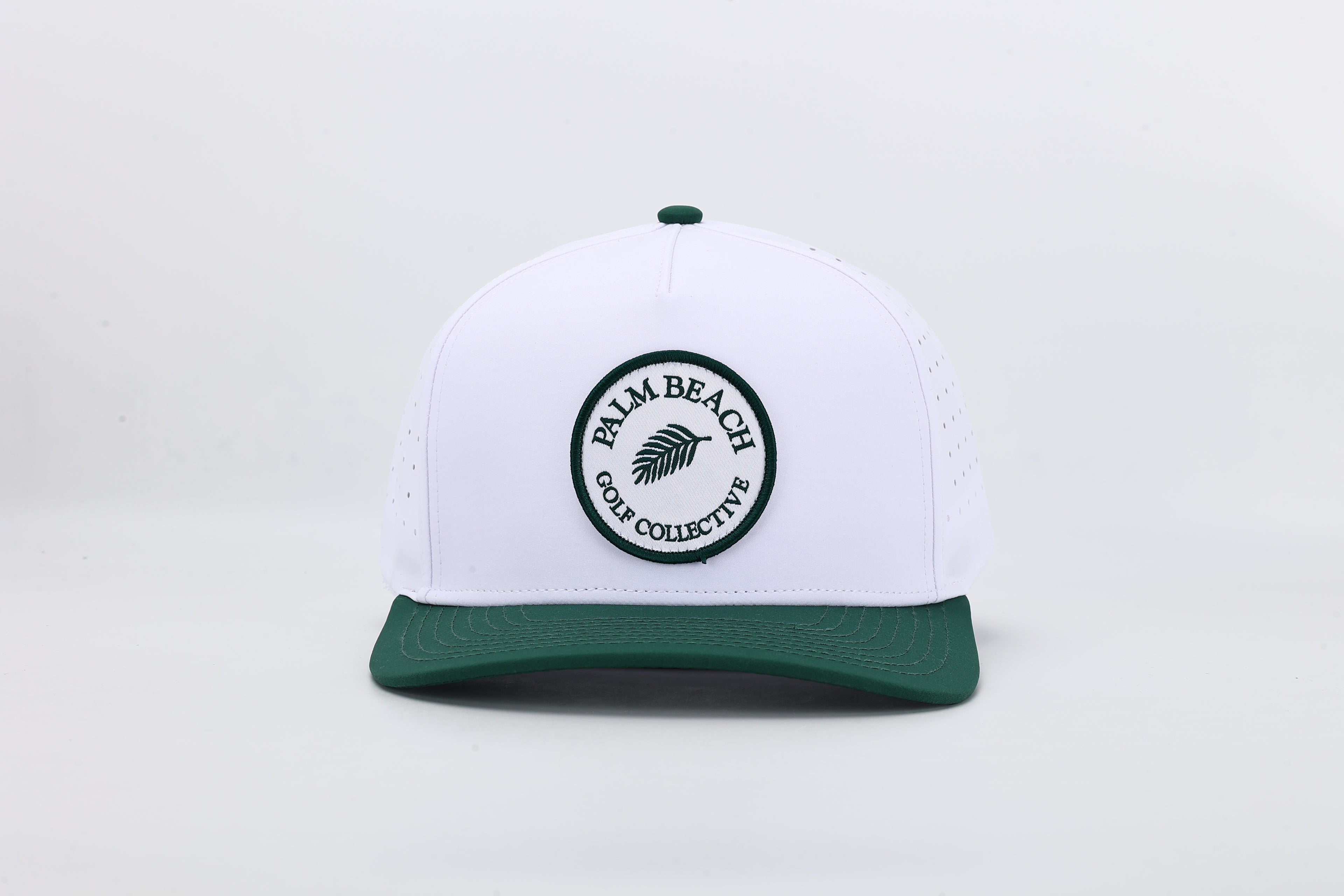 White cap with green brim and 'Palm Beach Golf Collective' logo on a light gray background