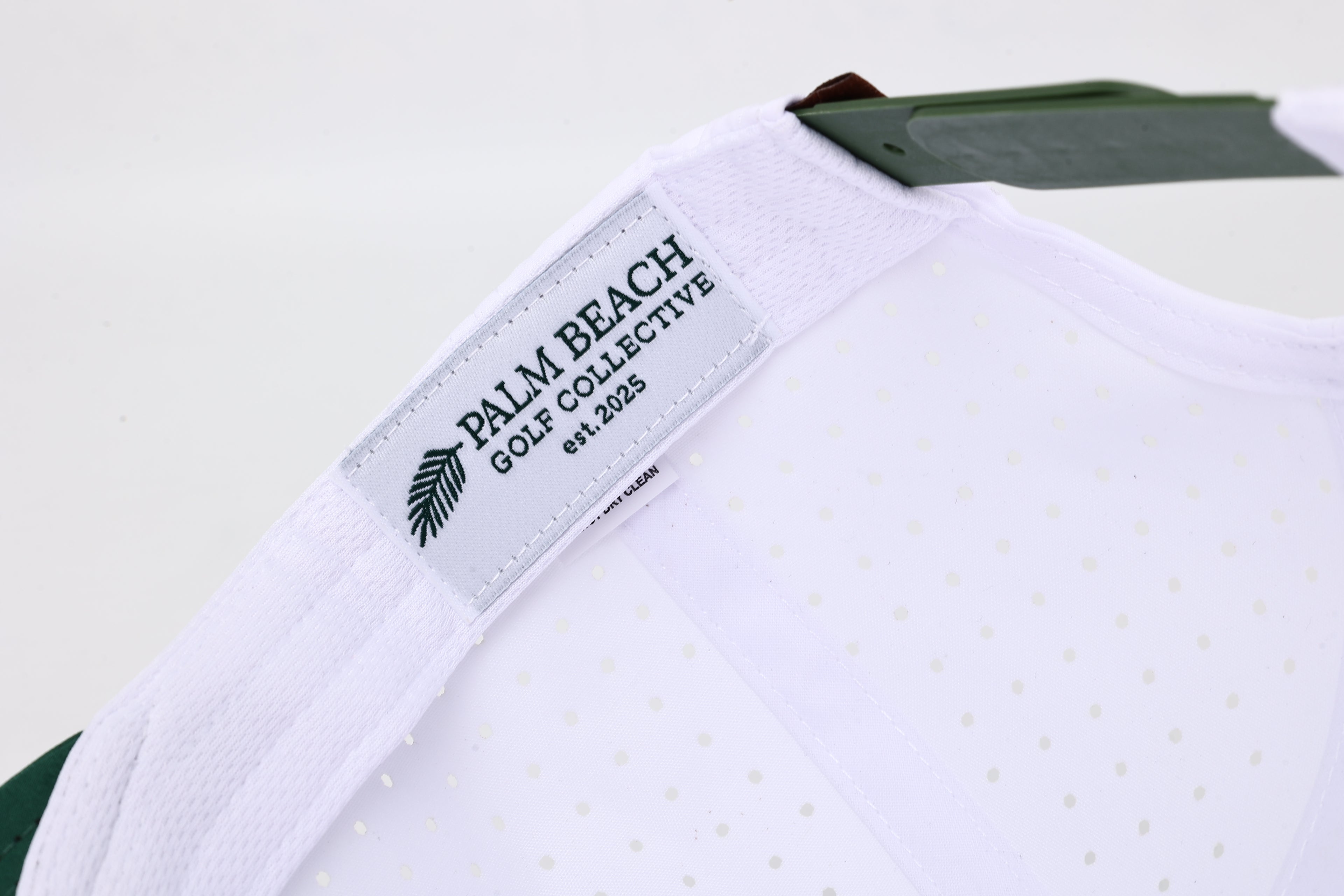 Close-up of 'Palm Beach Golf Collective' label on a light gray background