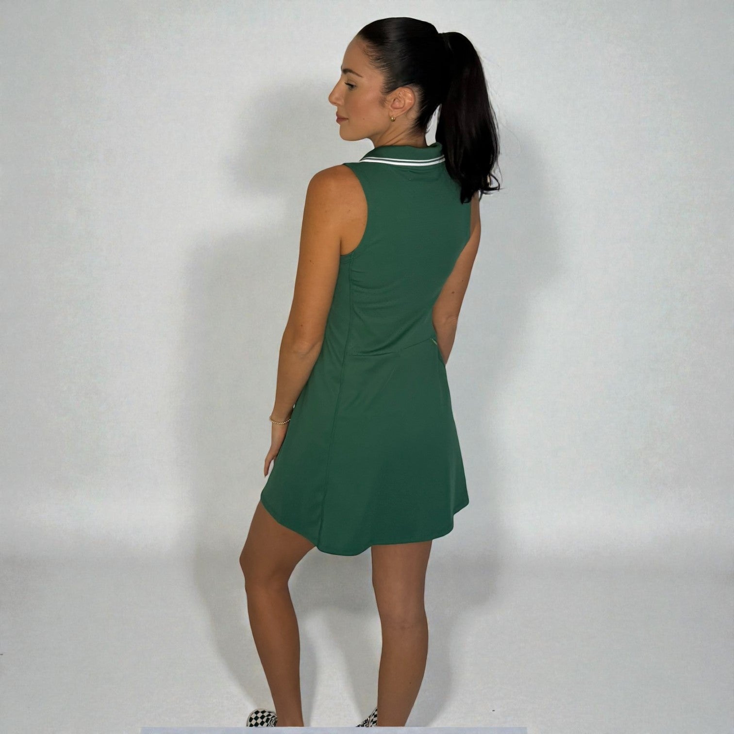Woman wearing a green dress against a plain background