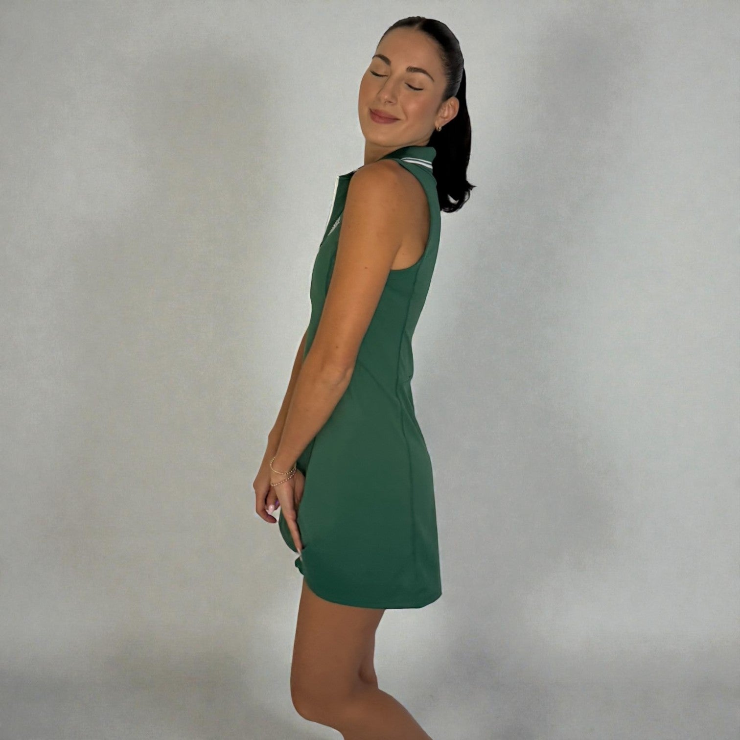 Woman wearing a green dress against a plain background