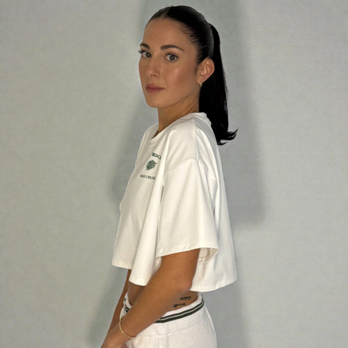 Woman wearing a white t-shirt with a logo against a plain background