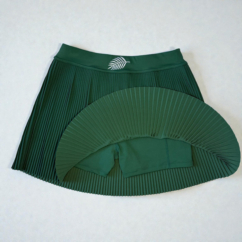 Green pleated skirt with a matching shorts on a white background