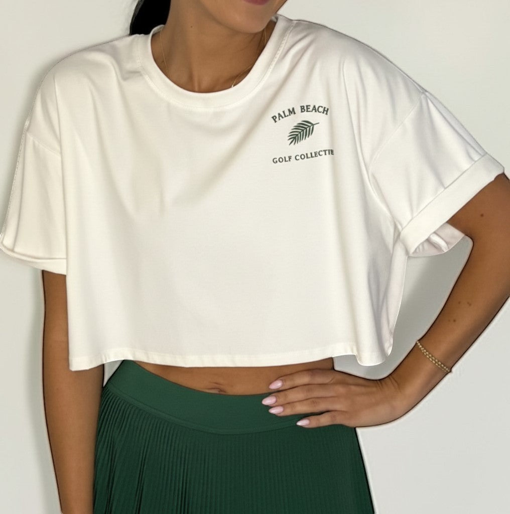 PBGC Clubhouse Crop Top in white with green palm leaf logo, featuring a relaxed oversized fit and short sleeves.