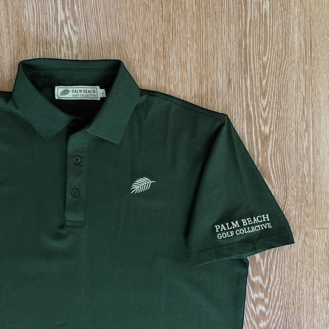 PBGC forest green performance golf polo with three-button placket, structured collar, and palm leaf chest logo