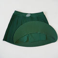 PBGC forest green pleated athletic skirt with built-in shorts and a white palm leaf logo on the high-rise waistband.