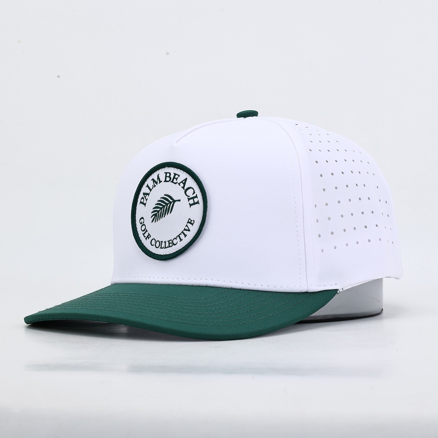 PBGC The Palm Patch Hat featuring a white crown with perforated sides, a green bill, and a circular palm tree logo.