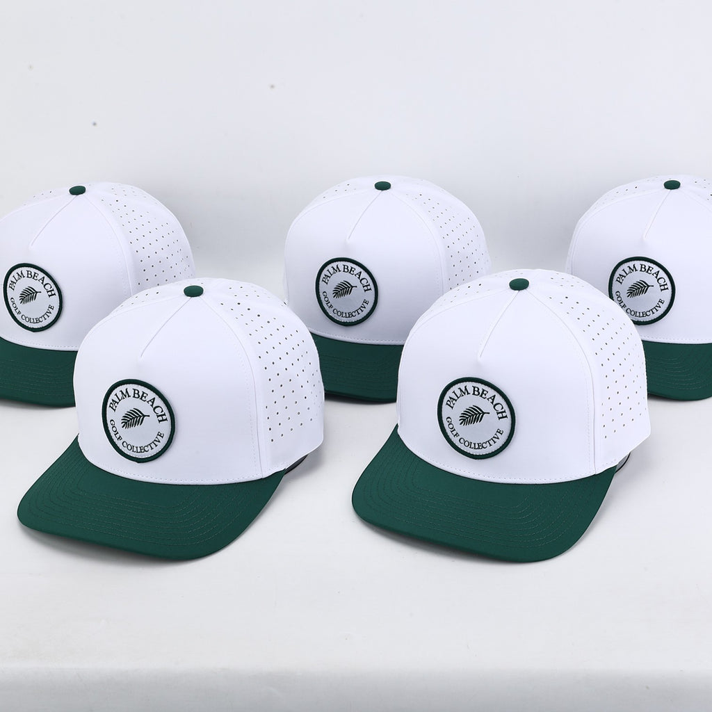 Five PBGC Palm Patch hats with white perforated crowns and deep green bills arranged on a white surface.