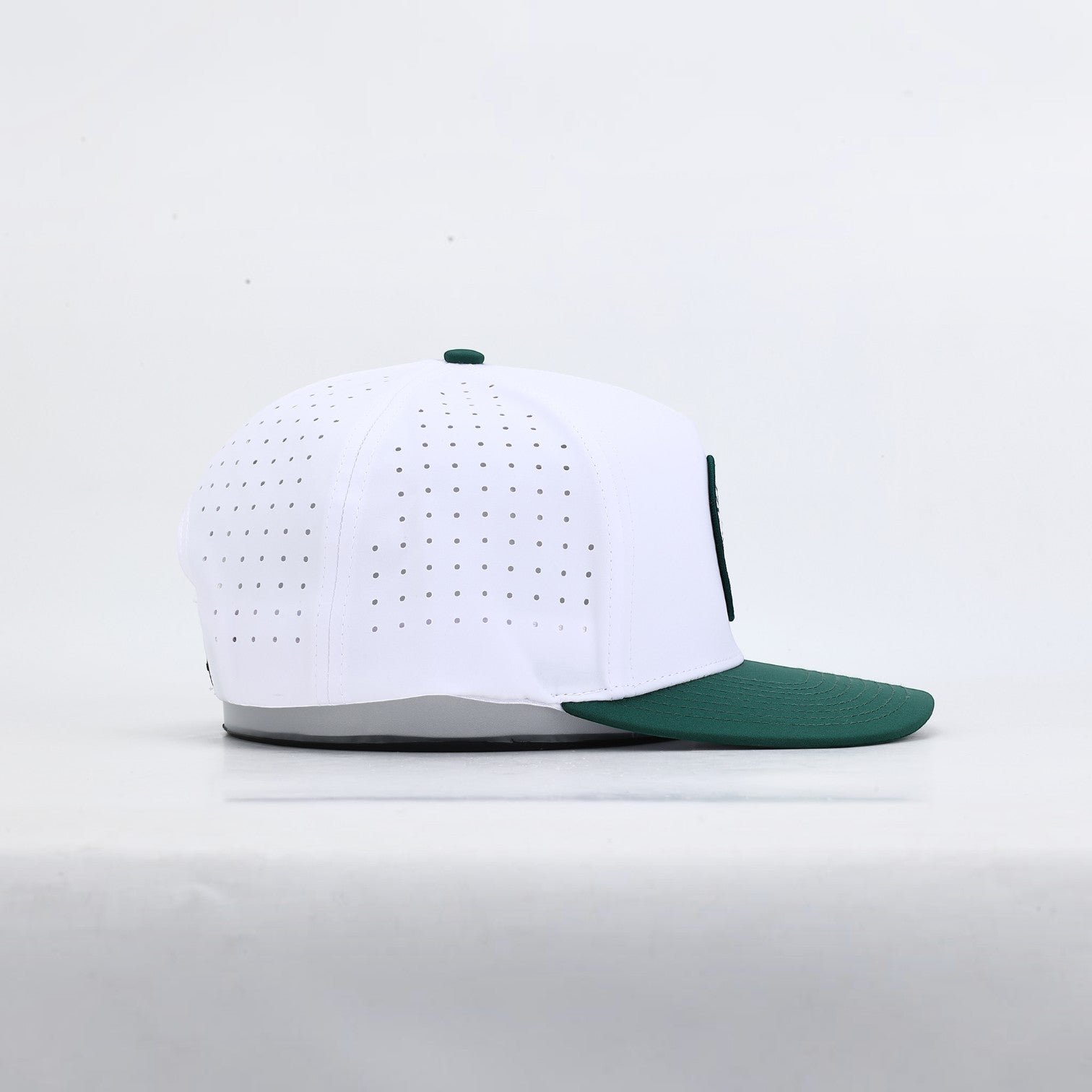 PBGC The Palm Patch Hat featuring a white perforated crown and deep green bill in a side profile view.