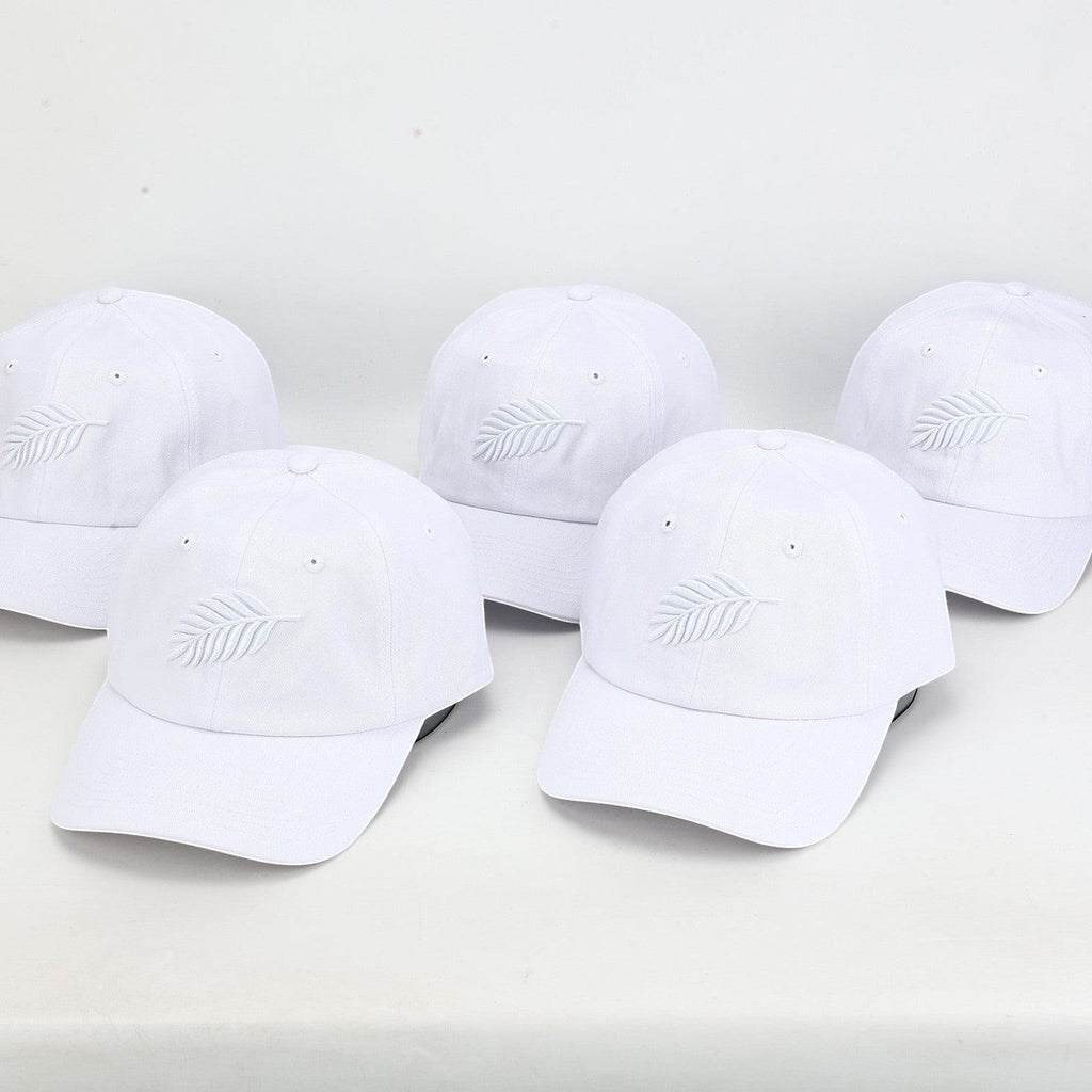 PBGC white cotton twill baseball caps with tonal embroidered fern leaf detail arranged in a group.