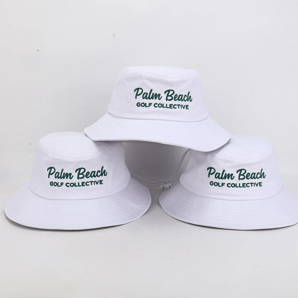 PBGC white bucket hat with deep green embroidered Palm Beach Golf Collective branding for golf sun protection.