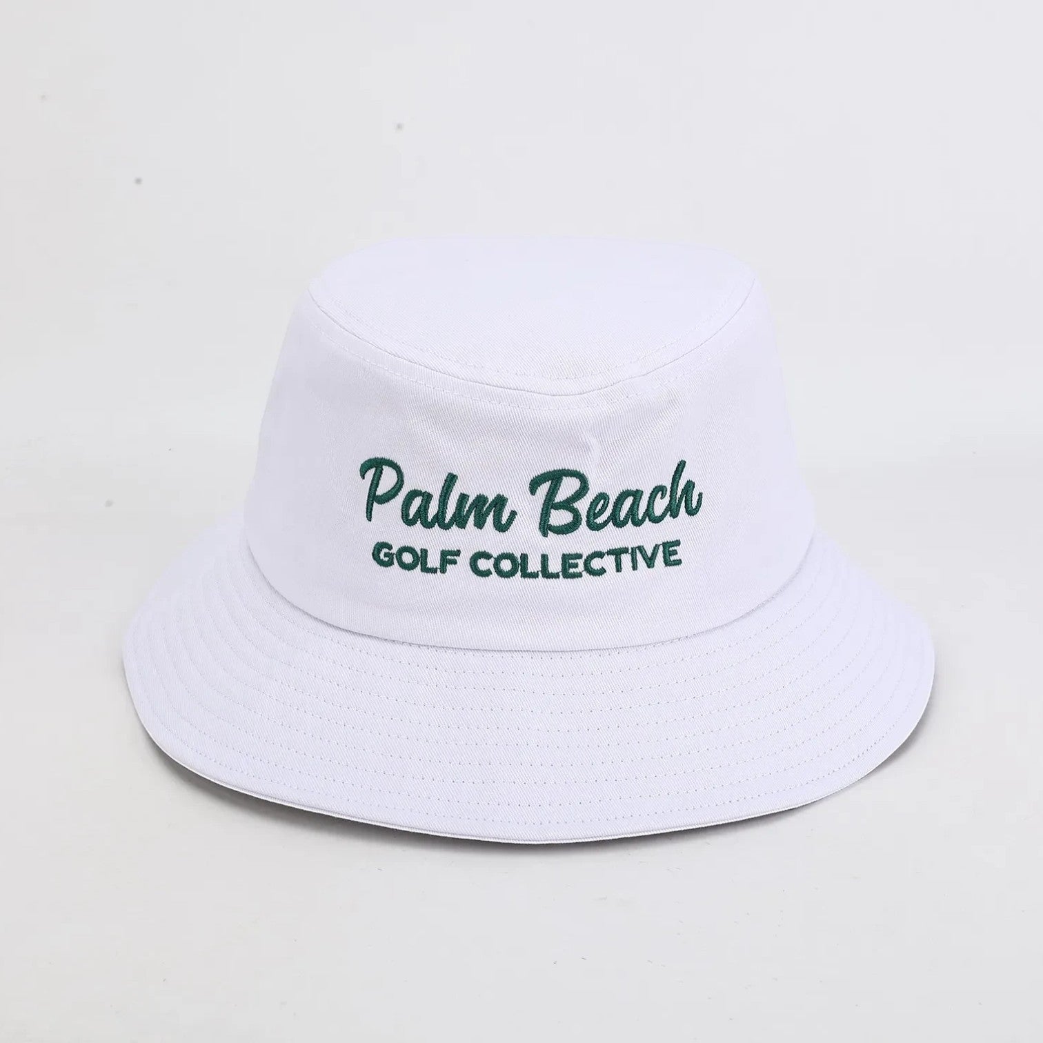 PBGC white bucket hat with green Palm Beach Golf Collective embroidery for sun protection on the golf course.