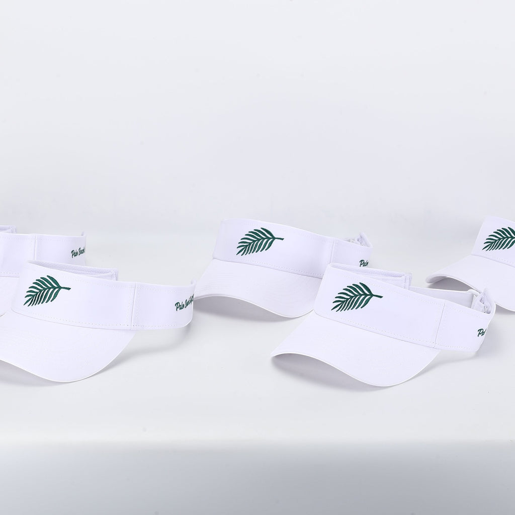 PBGC The Island Visor in white with green palm leaf embroidery, featuring a lightweight and breathable design.