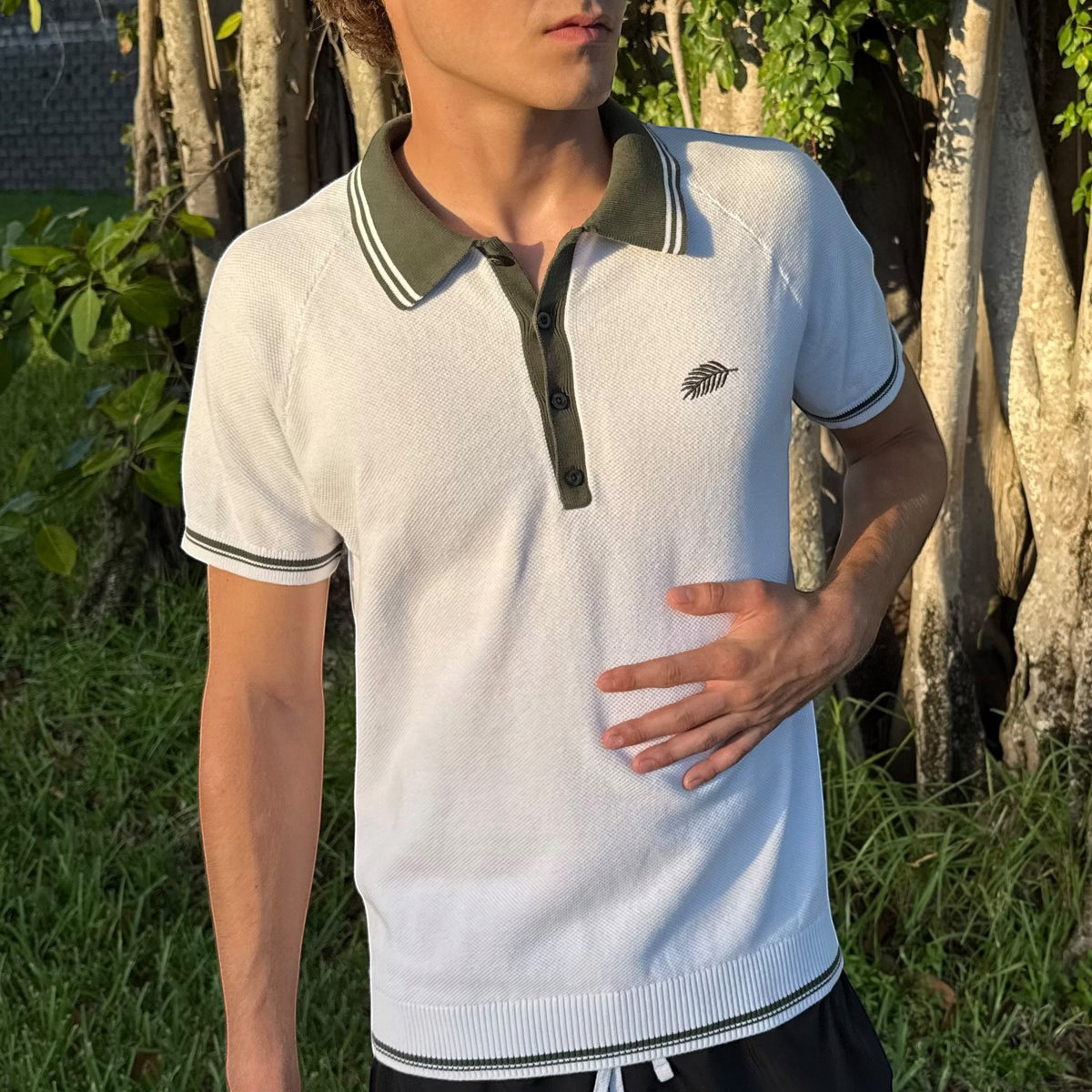 PBGC white cotton knit polo shirt with olive green striped collar and palm leaf embroidery on chest