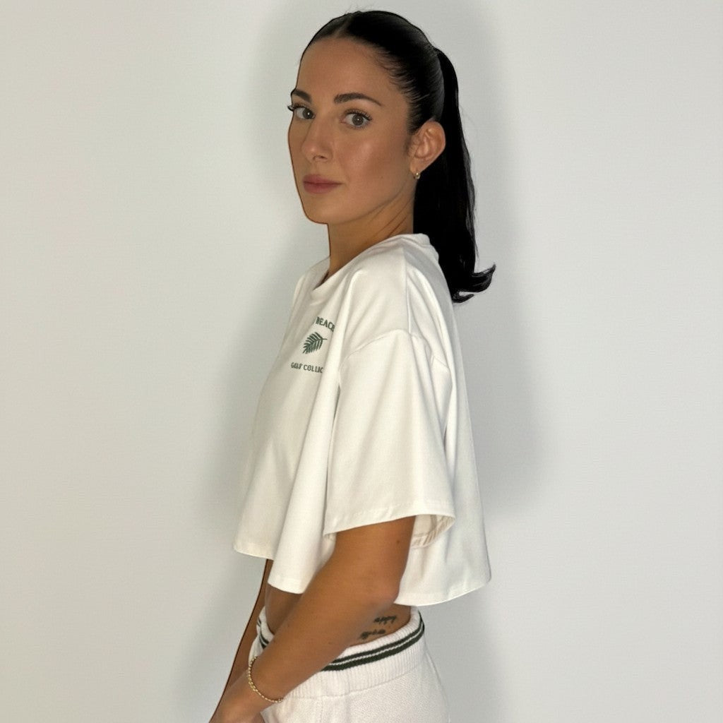 PBGC Clubhouse white oversized crop top with green graphic detail worn by a model in a side profile view