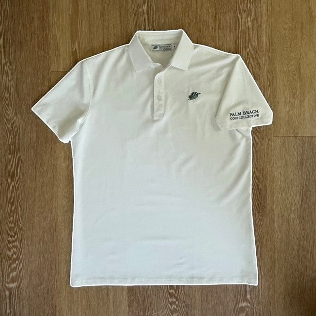 PBGC white performance golf polo with moisture-wicking fabric, palm leaf chest logo, and sleeve branding.