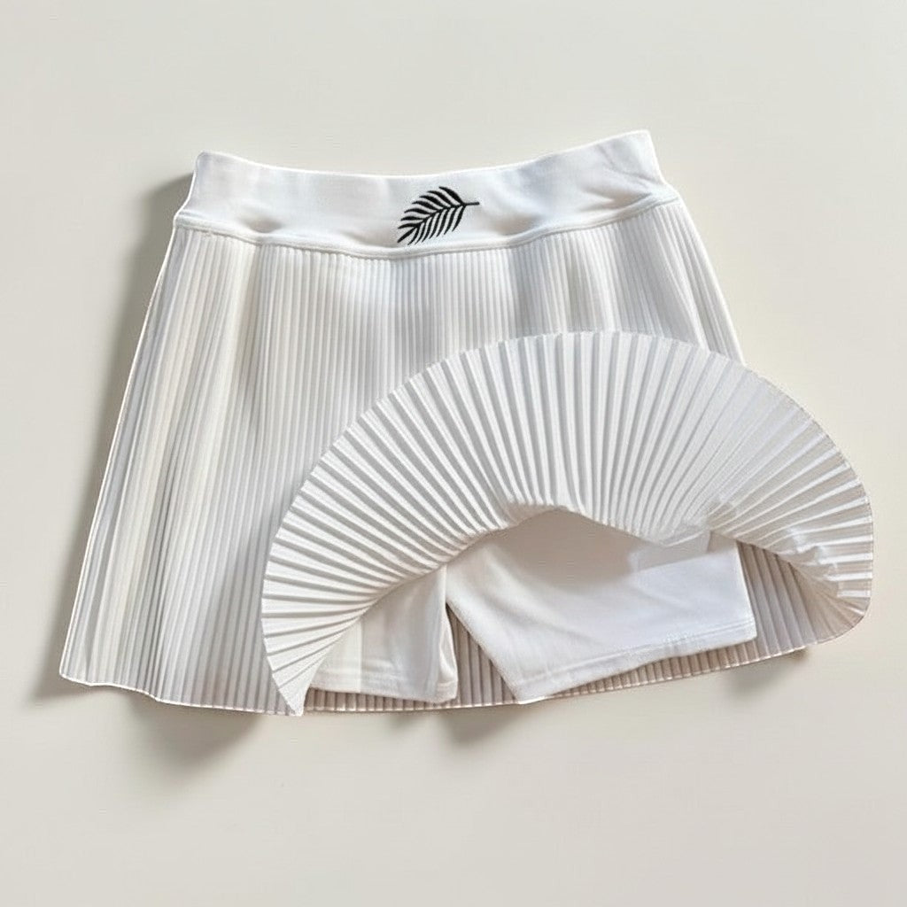 PBGC white pleated athletic skirt with high waist, leaf embroidery, and integrated inner shorts for tennis or golf.